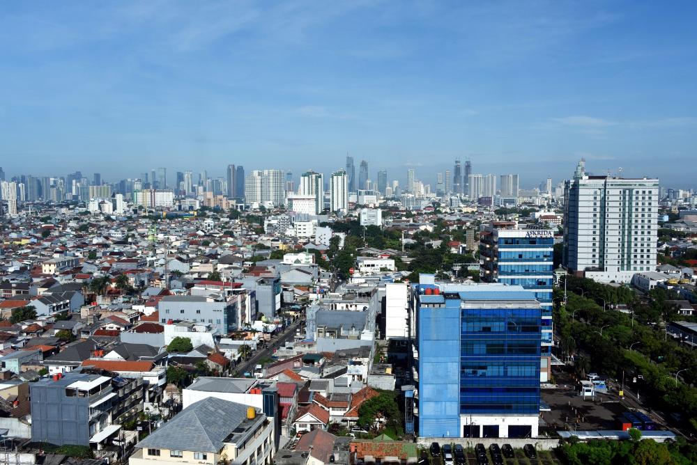 Dense urban cityscape with skyscrapers in distance.